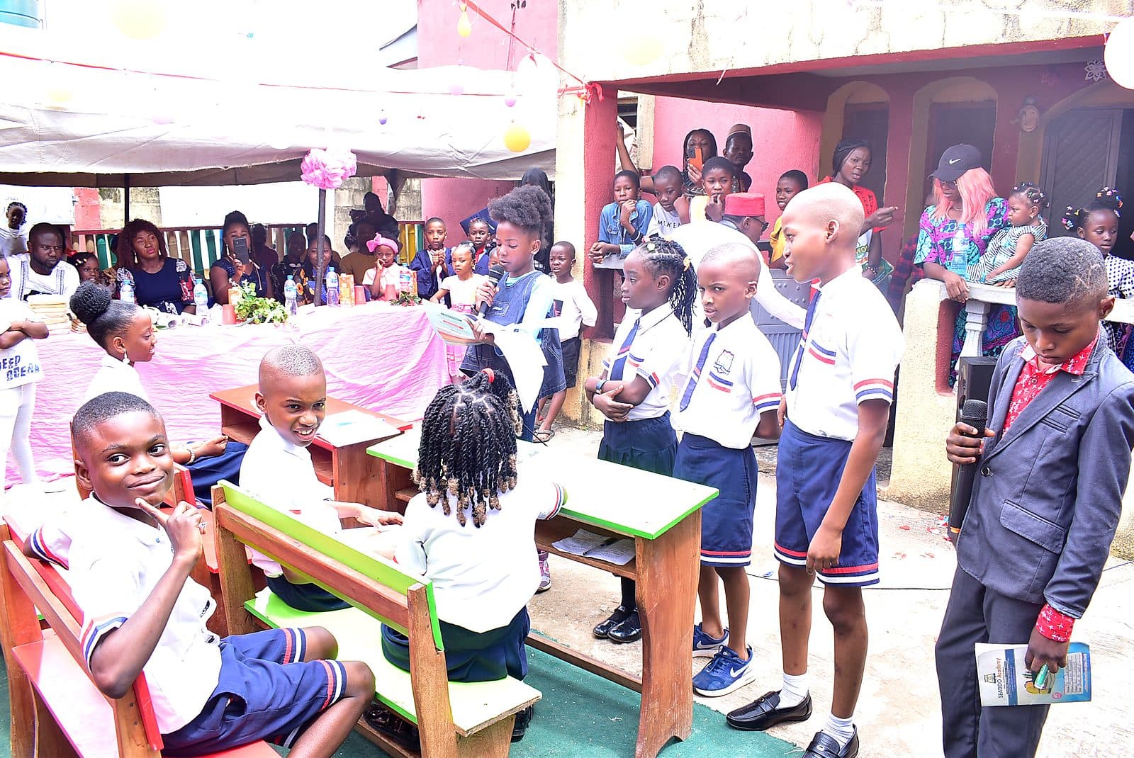 A classroom role play, with pupils at their desks in school uniform