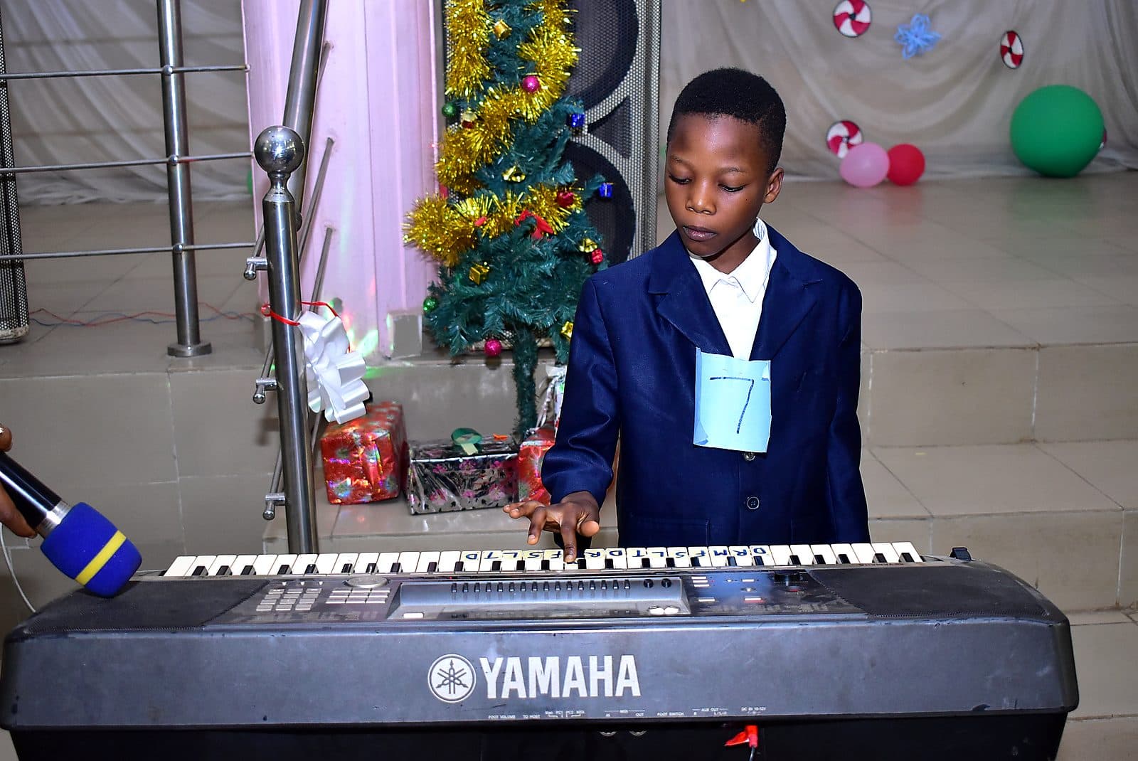 A pupil playing the keyboard at a school event