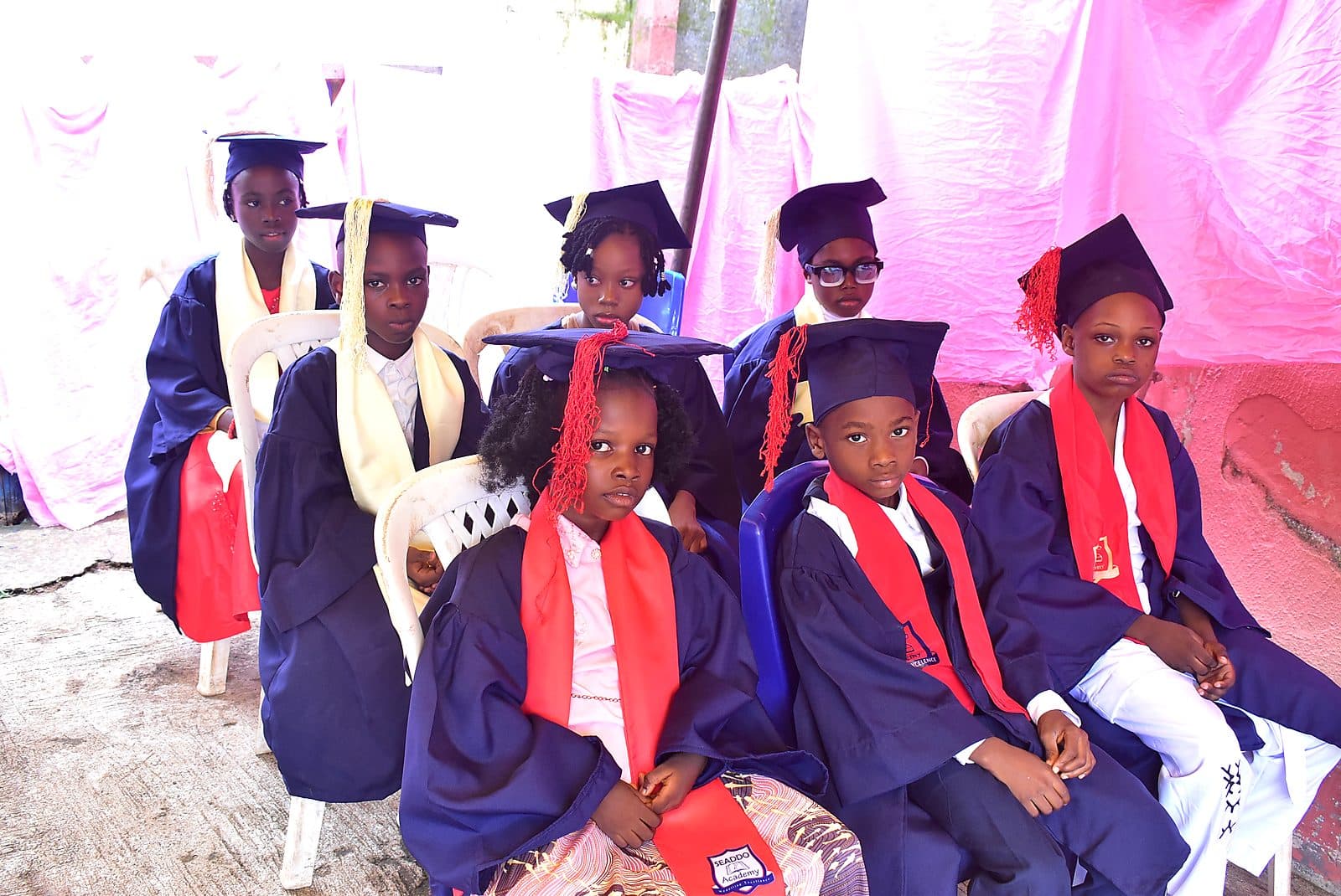 Graduating pupils seated in caps and gowns